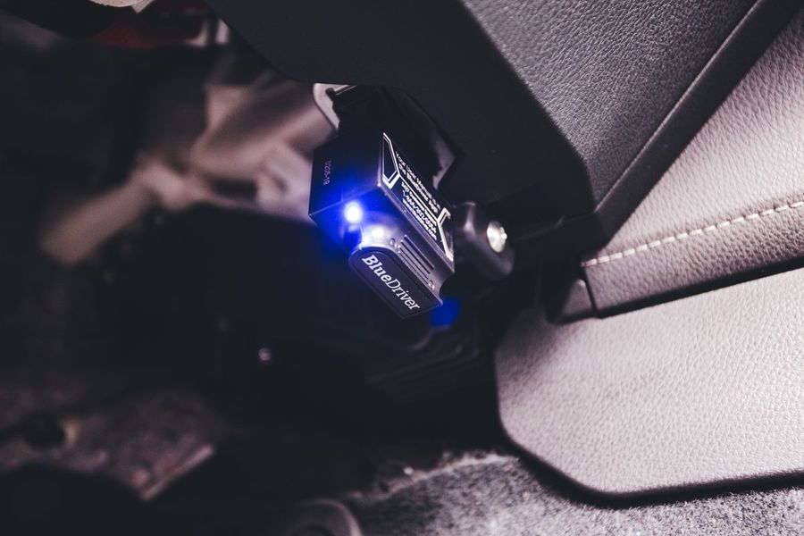 Диагностический OBD-сканер, подключённый к разъёму автомобиля